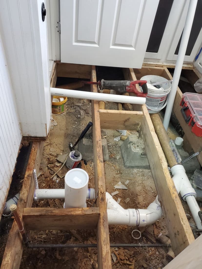 exposed plumbing and wooden beams in a home renovation project near a doorway